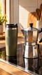 © Grace - Reusable cup next to stovetop moka pot on warm-toned hob in soft morning daylight