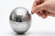 © ASAD DESIGN HUB - Hand placing last puzzle piece onto metallic globe against white background for global connectivity concept