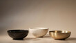 © soyibakter - Three decorative bowls in black ceramic white stone and polished brass on beige surface