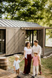 © BGStock72 - Joyful family stroll in a serene outdoor setting near their stylish cabin