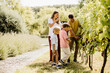 © BGStock72 - Family enjoying a sunny day harvesting grapes in a vineyard