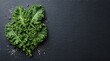 © ety - Fresh green kale leaf with sea salt on a dark textured slate background with copy space