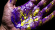 © Ganang Wahyu - Close-up of Human Palm Covered in Vibrant Purple and Yellow Liquid Paint Showing Skin Textures