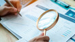 © ภาคภูมิ ปัจจังคะตา - Accountant examines financial reports with a magnifying glass in an office. Business audit concept for document review, accounting analysis, compliance,  evaluation, and quality control.