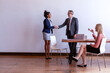 © Rawpixel.com - Business meeting with Black woman, white man, and blonde woman in office