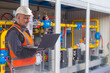 © Grispb - Gas industry, engineer monitors industrial gas distribution equipment with a laptop, checking pipelines, valves, pressure control and facility operation.
