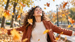 © ArtFocus Studio - Joyful woman opening her arms among falling autumn leaves
