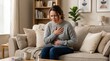 © mrizkiprasetio - A woman suffering from acid reflux disease, holding her chest with a painful expression while sitting on a sofa, neutral living room interior, realistic soft lighting, high resolution photo.