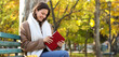 © Pixel-Shot - Mindfulness and mental health, young woman reading a book on a park bench during autumn for relaxation and personal growth in a peaceful outdoor setting