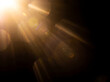 © Vectrology - Golden lens flare on black background, warm sun light leak, cinematic optical flare overlay