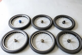 Bicycle maintenance and repair, set of six bicycle wheels with rubber tires and metal spokes arranged on a workshop floor for mechanical service