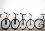Sustainable transportation and urban mobility, row of bicycles parked against a white wall for eco friendly commuting and healthy active lifestyle