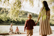 © BGStock72 - Family enjoying a sunny day by the serene lake with playful moments