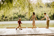 © BGStock72 - Family enjoying playful moments by the serene lakeside on a sunny day