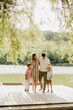 © BGStock72 - Family enjoying a sunny day by the lake on a wooden dock