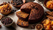 © syhin_stas - Dark, dense fruitcake partially sliced on linen, surrounded by bowls of dried apricots and raisins, cinnamon sticks, star anise and dried orange for a cozy holiday bake