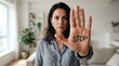 © Working Moments - A woman holding her hand up with STOP written on the palm to set boundaries against harassment.