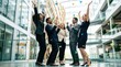 © Png guru - Excited diverse business team celebrating a major corporate victory with raised arms inside a modern glass office building atrium