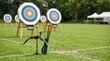 © OlgaNeuroArt - Archery bow and quiver with arrows on outdoor range. Target faces on grass field during competition practice