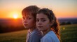 © Angavlan - Children watching sunset from hill with warm colors and soft glow illuminating their faces. Children sit close together enjoying beautiful sunset view from hilltop in peaceful setting.