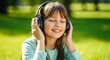© Angavlan - Girl enjoying music on grass with headphones, smiling and feeling upbeat in sunny park. Outdoor scene showcases joyful moments of childhood, with girl immersed in sounds of nature and melodies.