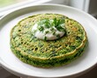 © Геннадий - Spinach pancake with sour cream and herbs on a white plate