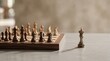 © UnPhouvith - A chess set sits on a wooden table, with the king prominently displayed. The chessboard is positioned on a light gray surface, creating a dramatic contrast.