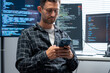 © Golf_MHNK - Caucasian developer reviews mobile app code on a laptop and phone, checking for vulnerabilities and logging remediation steps.