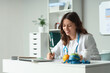 © Pixel-Shot - Nutrition counseling and healthy lifestyle, female doctor writing diet plan with fresh fruit and measuring tape on desk in medical office