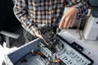 © Charlie's - Man Repairing Computer Hardware and Checking Internal Components in Professional Technology Workshop.