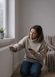 © redcat - Cold radiator winter interior with woman touching heater panel while