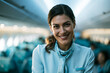© BlackBridge Media - Smiling Flight Attendant Standing in Airplane Cabin