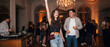 © itlada - Friends dancing at elegant party celebration in a luxurious ballroom with chandelier lighting, enjoying music and drinks during an upbeat nightlife event for hospitality advertising