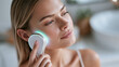 © Olha Havelia - European woman holding a sleek LED facial patch device near her cheek, soft green accent glow, cropped shot from below the eyes, bright minimalist bathroom, cosmetic technology con