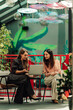 © Zamrznuti tonovi - Businesswomen collaborating on laptop in a modern coworking space, discussing project ideas during an informal meeting