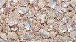 © Hamza - Assorted natural opal gemstones scattered on sandy beach surface for jewelry design inspiration