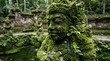 © AllYours - A serene and mysterious ancient stone statue covered in thick green moss, nestled within a tranquil jungle temple courtyard