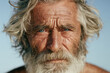 © StokHunt - Close up portrait of an elderly man with weathered skin, grey hair, and blue eyes looking at the camera