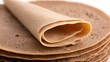© Sultana khatun - Stack of thin brown crepes or pancakes with one folded on a white background surface