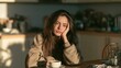© Pricha - Iron deficiency signs. Young woman sitting at a kitchen table in the morning, feeling low energy and sleepy.