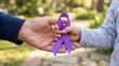 © HIJRAH - Generosity And Hope Symbolized By Shared Purple Ribbon In Gentle Outdoor Light