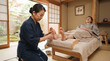 © Khemmanat - Tranquil Foot Massage in Traditional Setting: A skilled therapist gently massages a client's foot in a serene, traditional Japanese room, fostering deep relaxation and well-being.