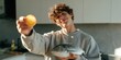 © Andrii Zastrozhnov - Young man offering lemon while holding a fresh fish in kitchen for culinary background and food banner design