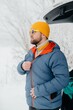 © dsheremeta - Man zipping winter jacket for solo hiking adventures
