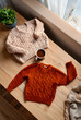 © Pixel-Shot - Hygge lifestyle and autumn comfort, cozy knitted sweaters with coffee on a wooden table for seasonal fashion and home relaxation in a bright room