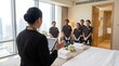 © Olga Ко - Female hotel manager or housekeeping supervisor with a digital tablet conducting a morning briefing for a team of maids. Staff training, quality inspection, and teamwork concept in a luxury hotel roo