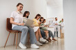 © Pixel-Shot - Healthcare waiting room, patients waiting for medical appointment with doctors in background, digital health and modern clinic service experience