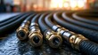 © Oulaphone - Close-up of hydraulic hoses with brass fittings arranged in parallel on a textured surface, illuminated by warm light in an industrial setting.