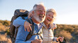 © CinimaticWorks - happy senior couple laughing together while hiking with backpacks on a scenic mountain trail