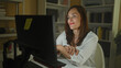 © Krakenimages.com - Woman middle age sits at computer smiling, hands folded on desk and keyboard in building at night; contentment productivity concentration.